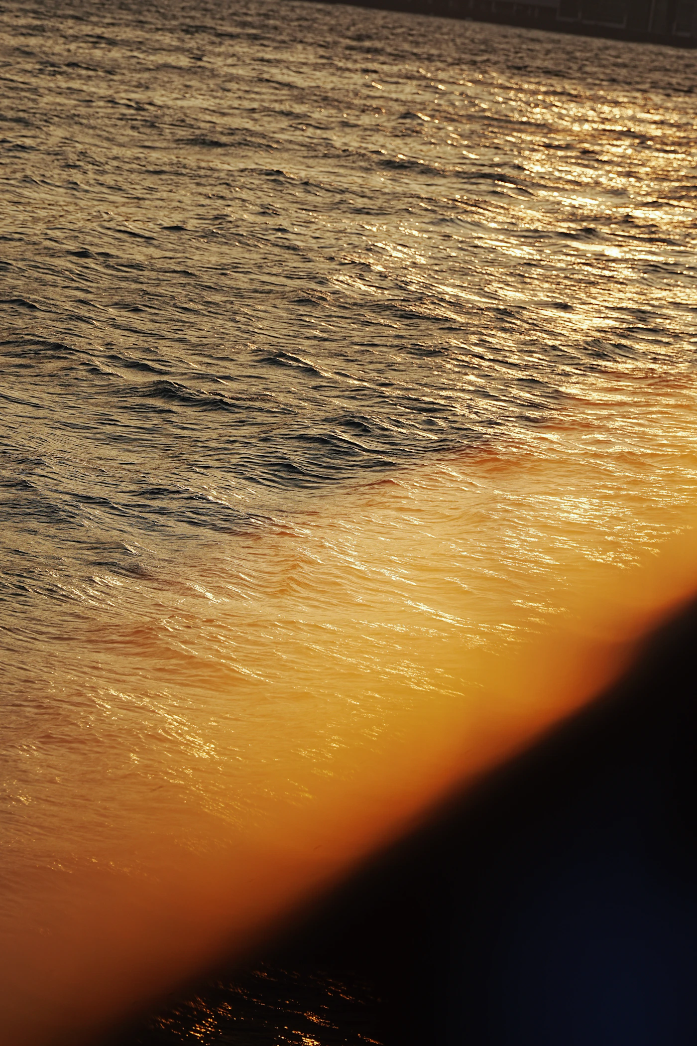 Golden sunlight reflecting across ocean waves
